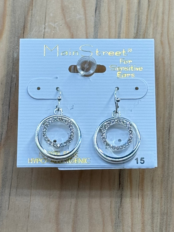 A pair of silver hoop earrings with embellishments, packaged on a card branded 'Main Street', marked as hypoallergenic for sensitive ears.